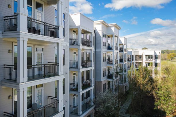 Modern apartment buildings with balconies surrounded by greenery